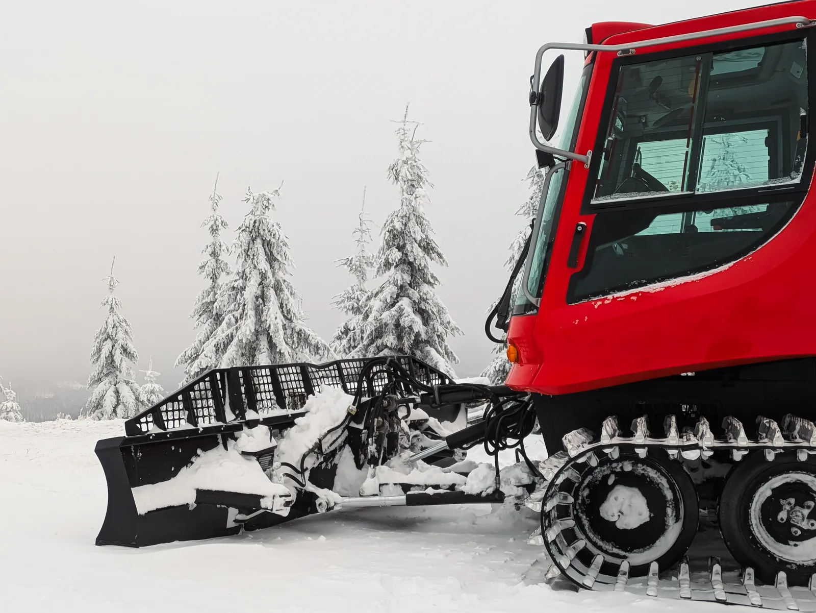 A bright red snowcat on snowy terrain with frosted trees, illustrating winter resort operations. Photo by Anatolii Grytsenko on Pexels