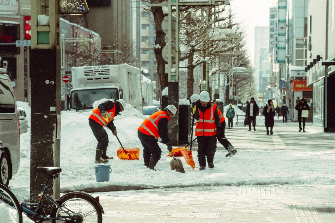 Urban street with workers shoveling snow in Hokkaido, Japan captured during winter. Photo by Dương Nhân on Pexels