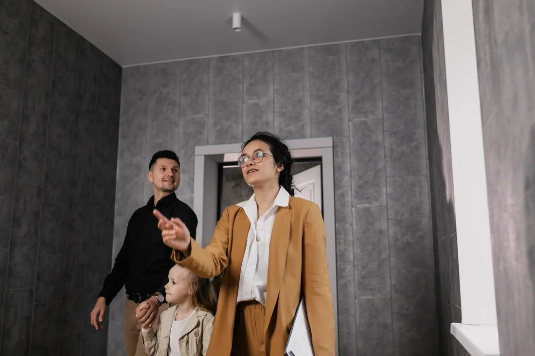 A family explores a modern home interior with a professional realtor guiding them. Photo by Alena Darmel on Pexels