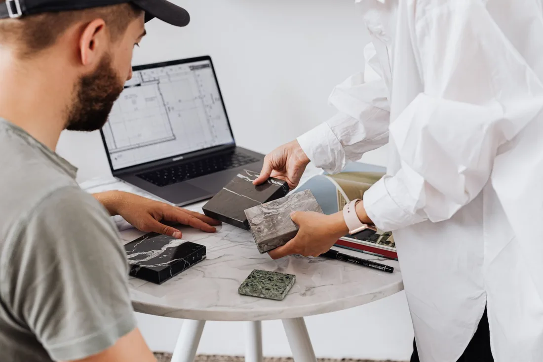 Homeowner and designer comparing tile samples with a laptop at a table. Photo by https://kaboompics.com/ on Pexels
