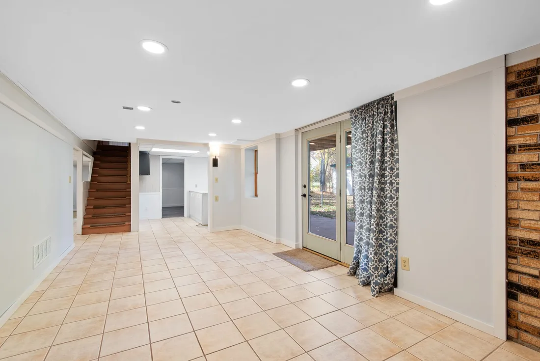 Bright finished basement with tiled floor, stairs and a window. Photo by Đỗ Huy Hoàng on Pexels