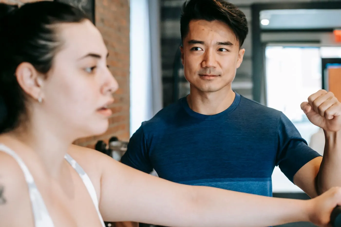 Personal trainer coaching a client in a gym. Photo by Andres  Ayrton on Pexels