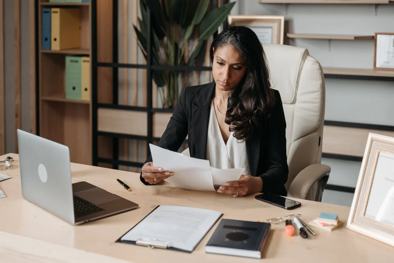 Lawyer reviewing documents at her desk with laptop in a bright office. Photo by Pavel Danilyuk on Pexels