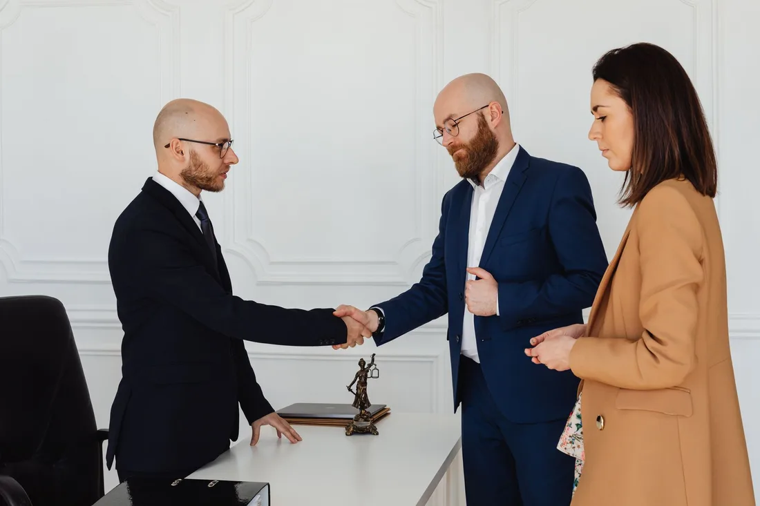 Lawyer shaking hands with a client in a bright consultation room. Photo by https://kaboompics.com/ on Pexels