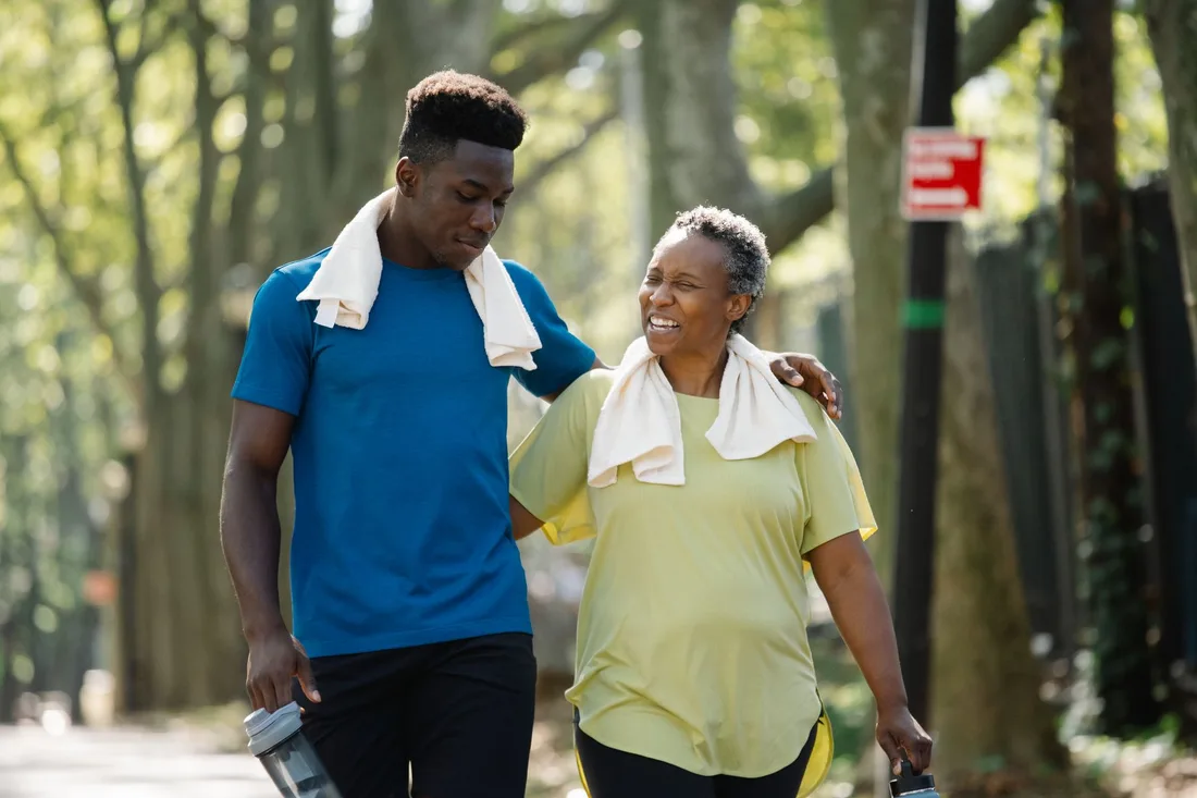 Smiling man and woman walking together outdoors in a park after recovery. Photo by Liliana Drew on Pexels