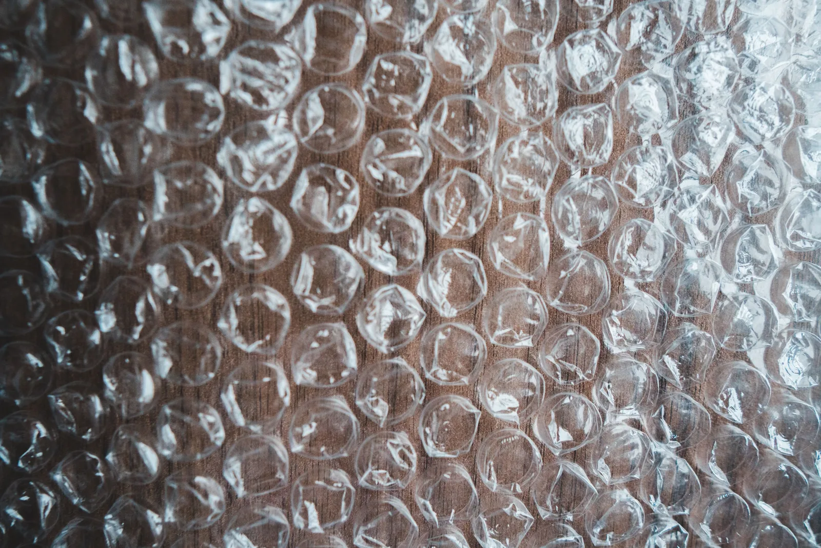 Overhead view of textured background representing seamless bubble wrap sheet with shiny uneven surface. Photo by Erik Mclean on Pexels