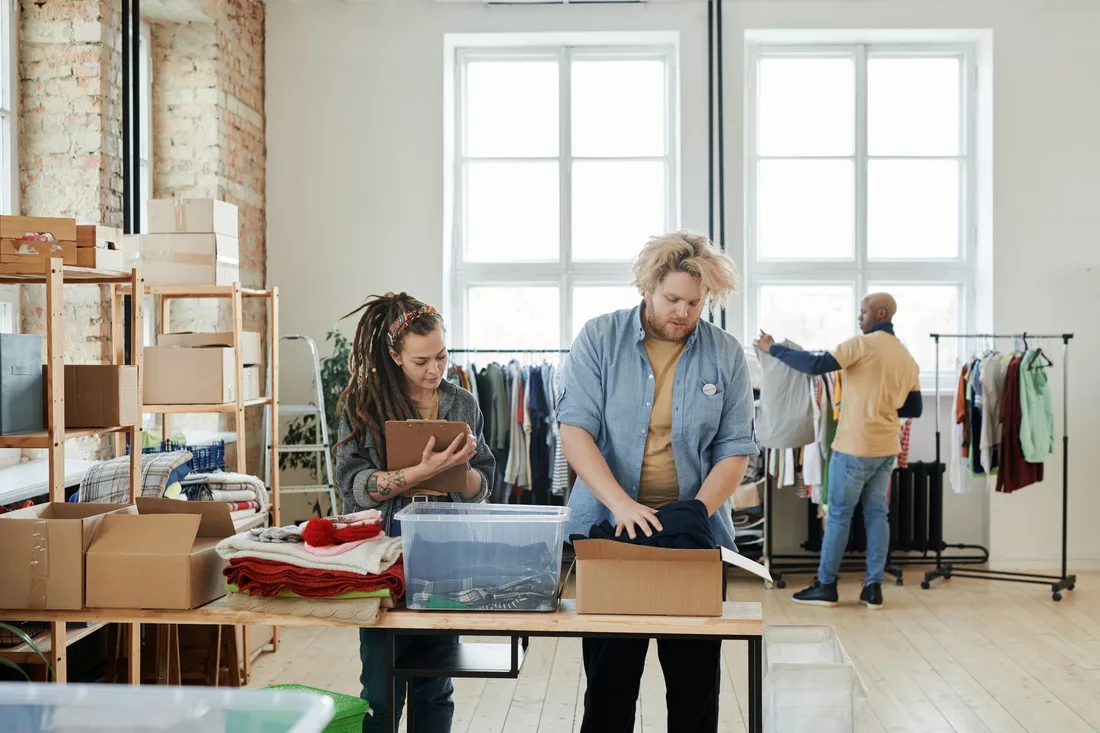 Small business team packing online orders in a bright studio with clothing racks. Photo by Julia M Cameron on Pexels