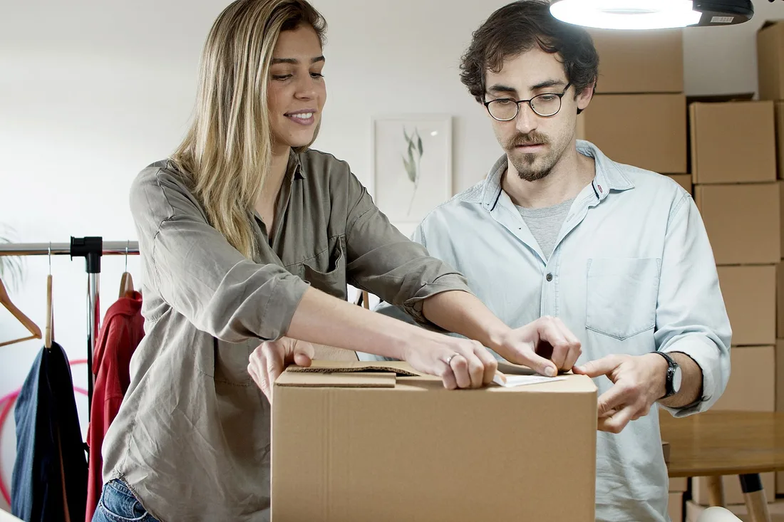 A young man and woman pack boxes in a modern office environment, symbolizing a startup business.. Photo by Kampus Production on Pexels