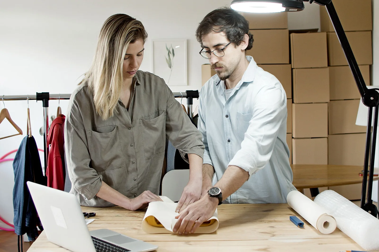 Team members packing orders in an online store's workspace, exemplifying efficient teamwork.. Photo by Kampus Production on Pexels