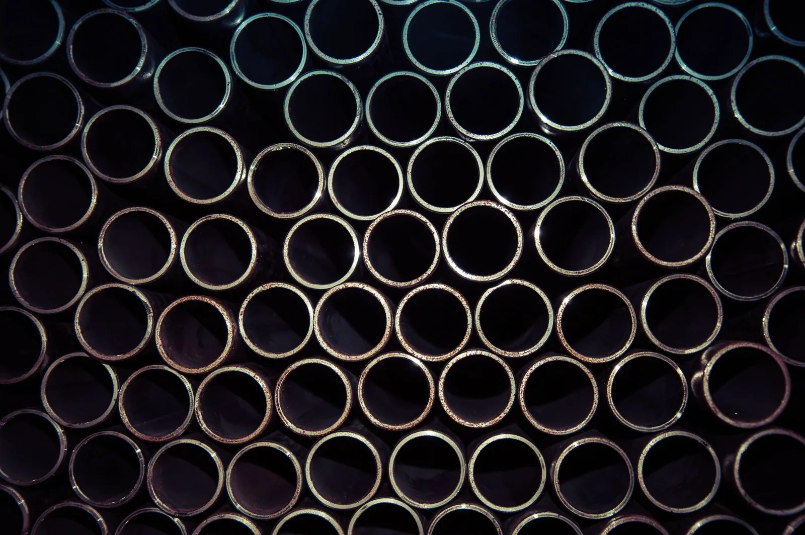 A detailed macro shot of stacked metal tubes forming a circular pattern, highlighting industrial design.. Photo by SHOCKPhoto by Szoka Sebastian on Pexels