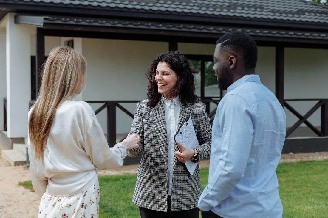 Couple shaking hands with a real estate agent on the lawn of a single-storey house. Photo by Thirdman on Pexels