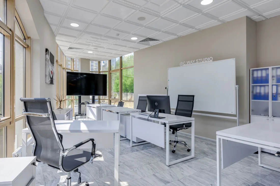 Bright open-plan commercial office space with desks, chairs and a whiteboard. Photo by Max Vakhtbovych on Pexels