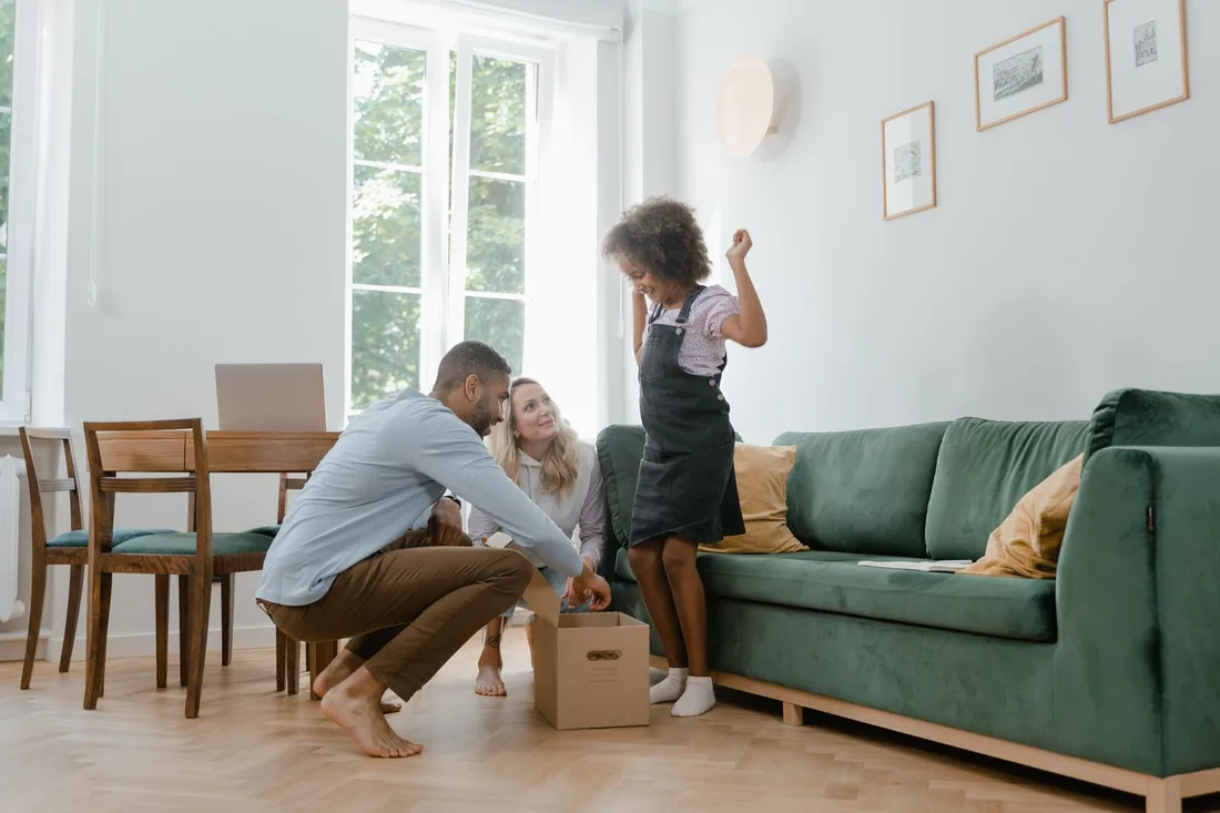Family relaxing and playing in a bright living room with a green sofa. Photo by MART  PRODUCTION on Pexels