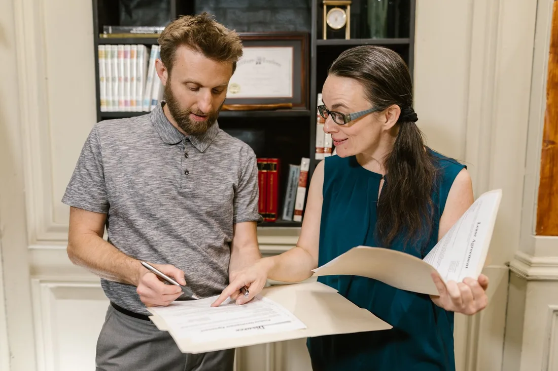 Tenant and landlord signing a lease agreement together at a desk. Photo by RDNE Stock project on Pexels