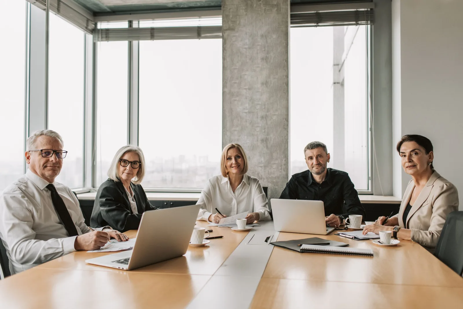 Strata committee members seated around a conference table with a laptop in a bright office. Photo by Vlada Karpovich on Pexels