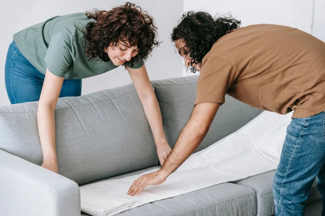 Couple inspecting a gray sofa together as they set up their home. Photo by Blue Bird on Pexels