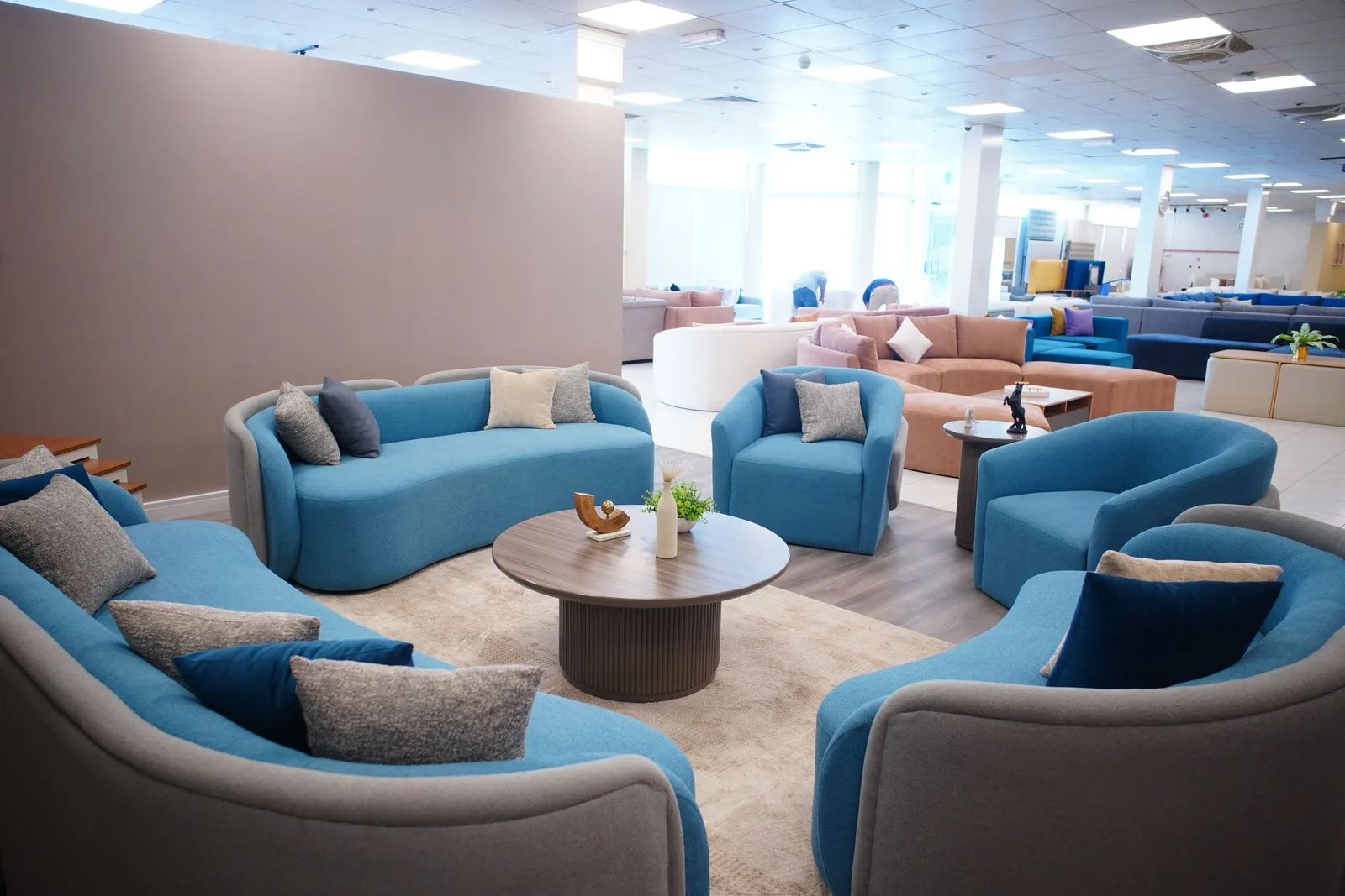 Furniture showroom with blue sofas and armchairs arranged around coffee tables. Photo by Atul Mohan on Pexels