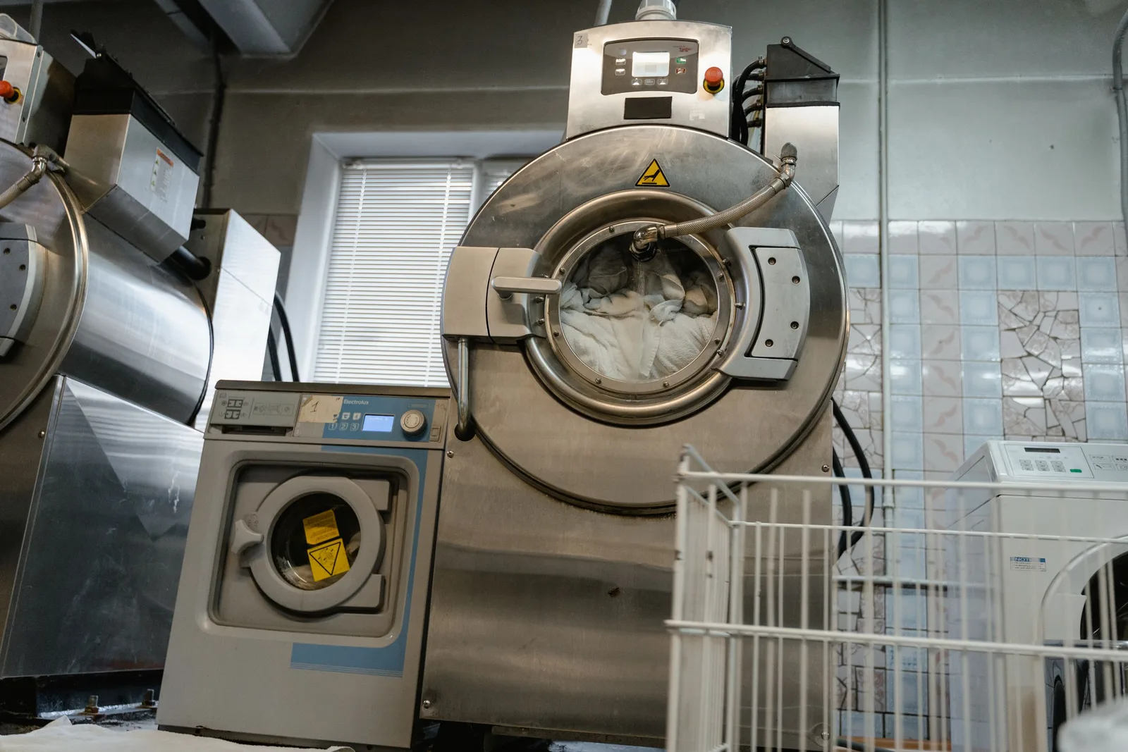Large industrial laundry machines in a service room environment. Photo by Tima Miroshnichenko on Pexels