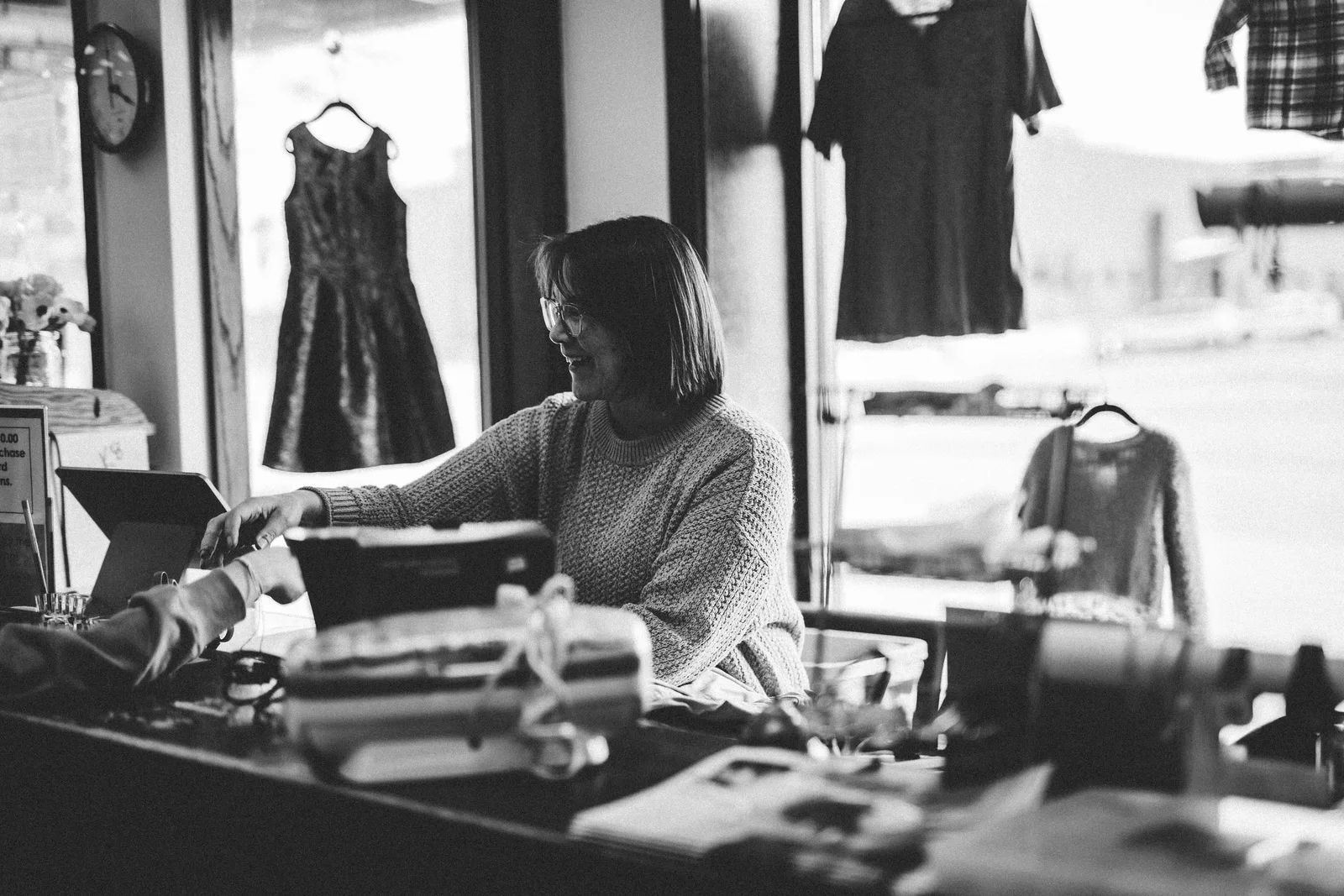 A woman happily assisting a customer at a thrift store counter in Minnesota, USA. Photo by Steph Quernemoen on Pexels