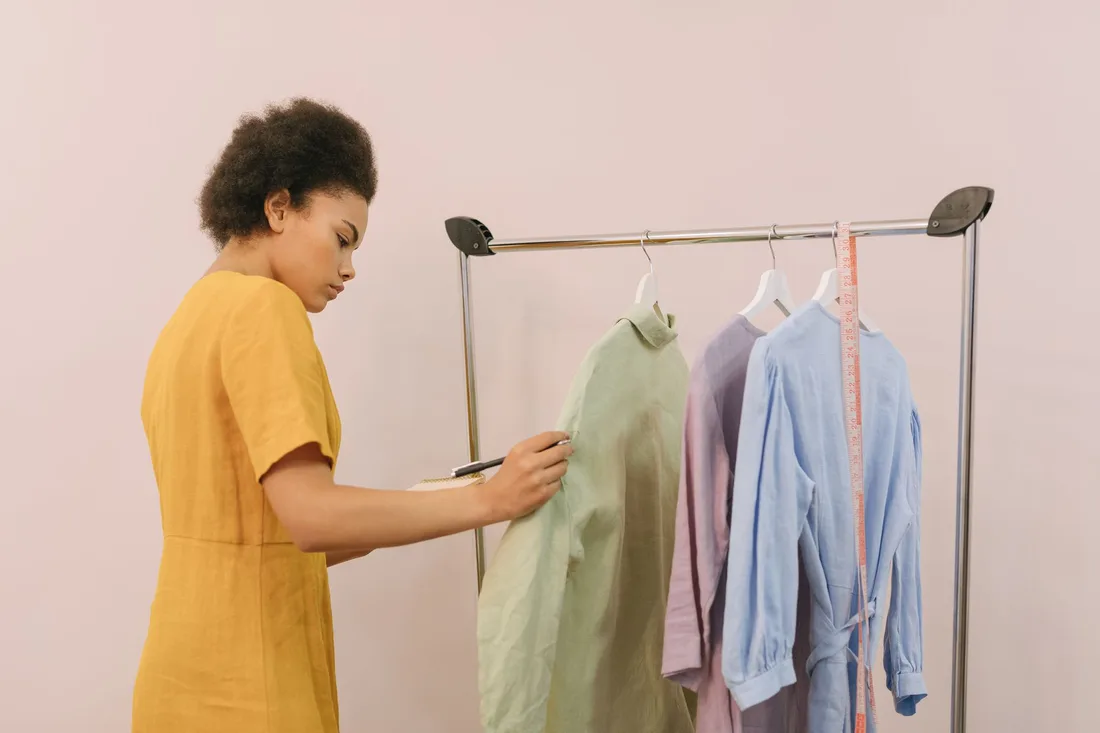 Woman checking clothing items on rack in boutique for inventory. Photo by Thirdman on Pexels