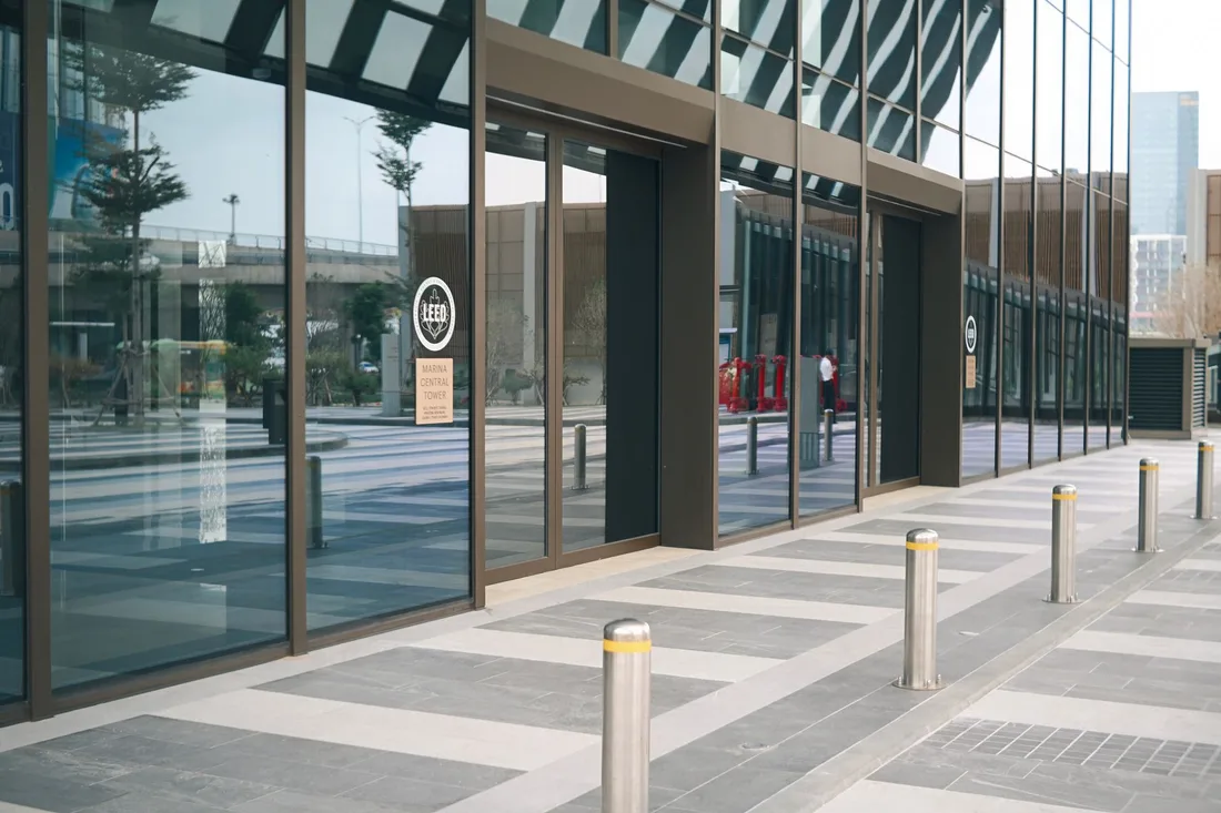 Glass fronted commercial building entrance with paved forecourt and bollards. Photo by 🇻🇳🇻🇳 Việt Anh Nguyễn 🇻🇳🇻🇳 on Pexels
