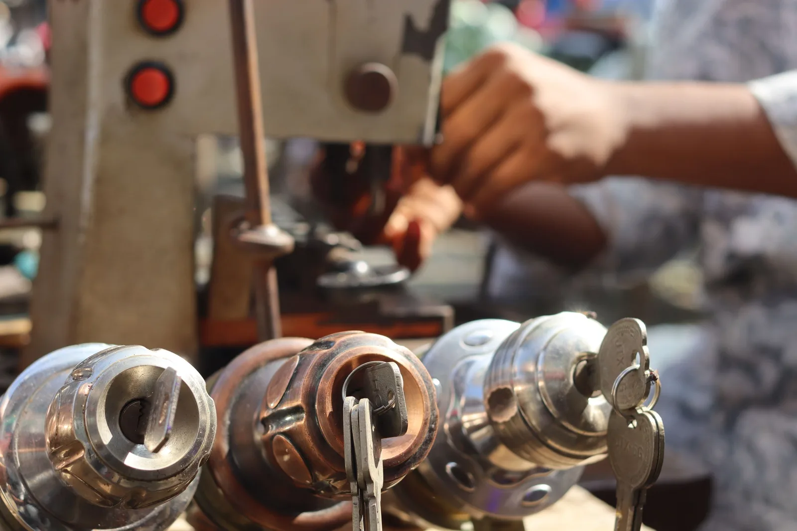 Locksmith cutting a key on a key duplicating machine with lock cylinders in view. Photo by Saad Bin  Hasan on Pexels