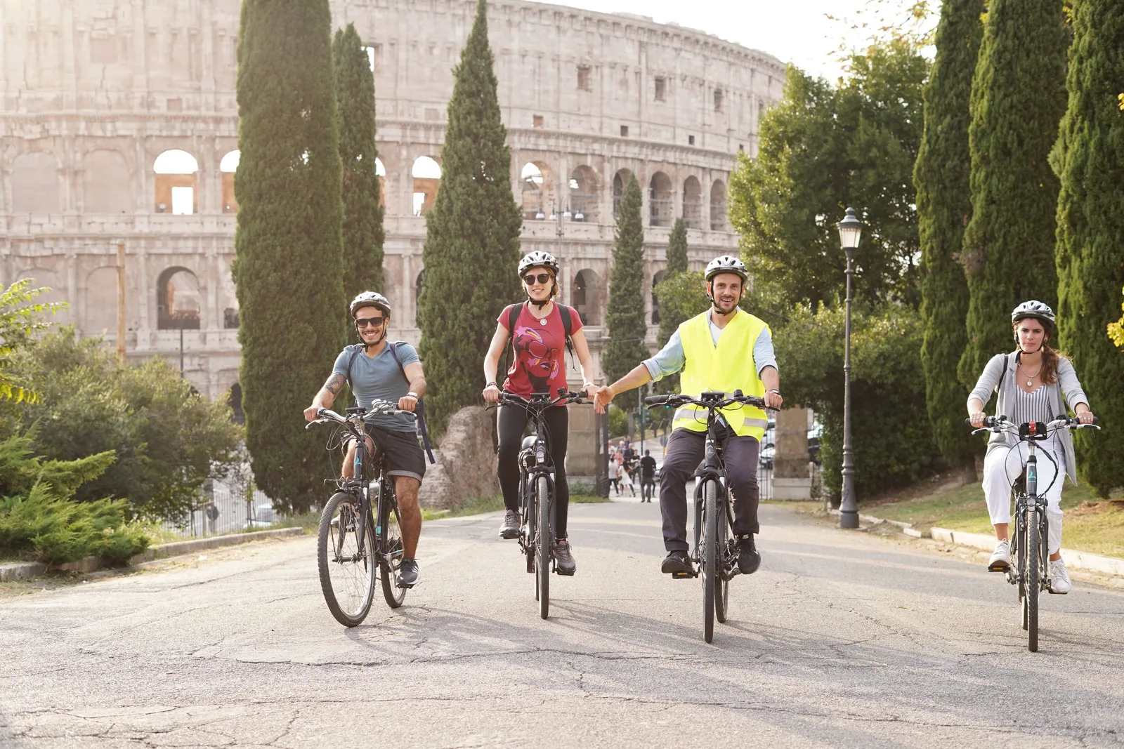 Group of tourists cycling together on a road near the Colosseum in Rome. Photo by Carlo A on Pexels