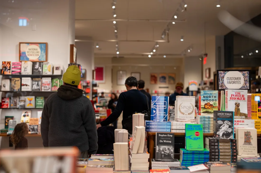 Warmly lit bookstore in New York City with people browsing through bookshelves. Photo by Jamie Kimball on Pexels