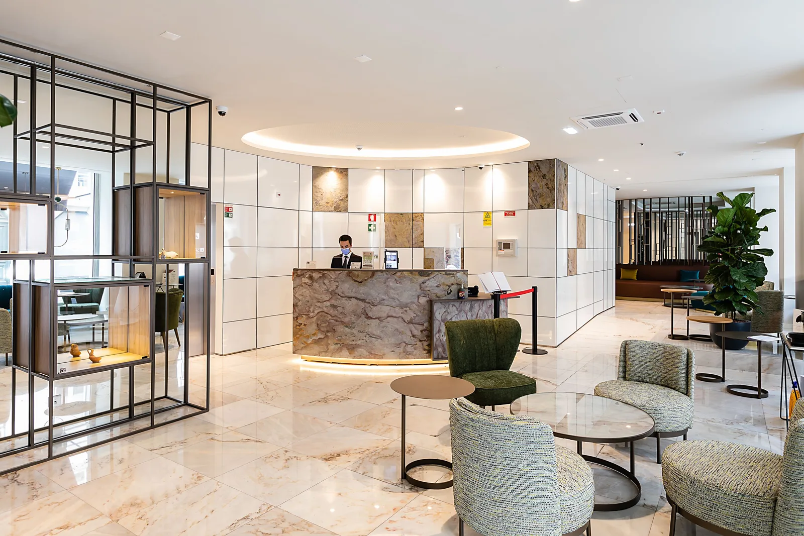Bright modern hotel lobby with a reception desk and seating area. Photo by The 7 Hotel Lisbon on Pexels