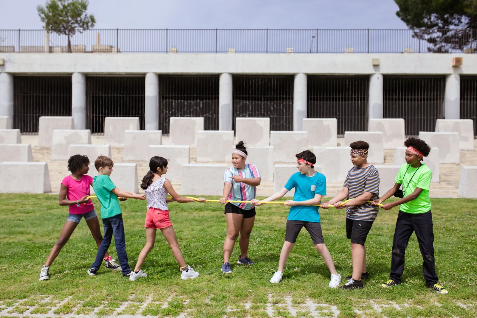 Group of kids playing tug of war outdoors at summer camp, enjoying a fun team building activity. Photo by RDNE Stock project on Pexels
