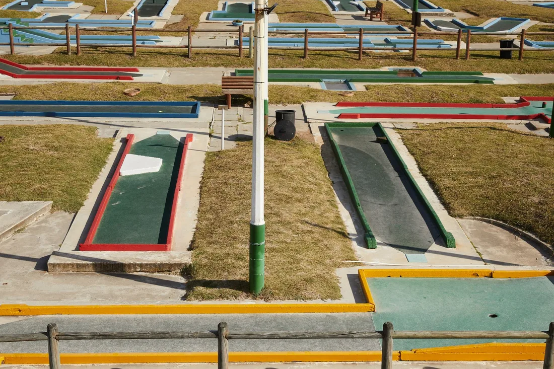 Colorful miniature golf course with several putting lanes seen from above. Photo by Laker on Pexels