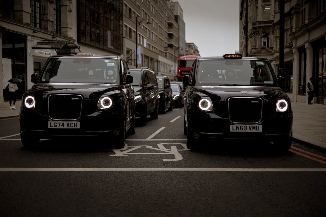 Black taxis line up on a London street showcasing modern urban transportation. Photo by Anatolii Grytsenko on Pexels