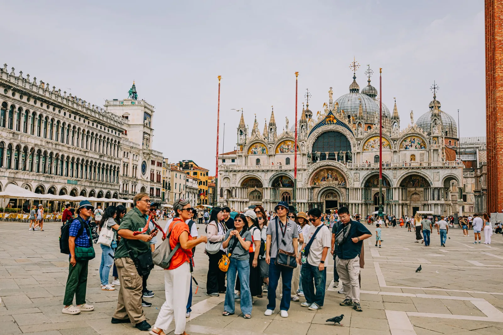 Tourists gathering in a sunny historic square in front of a grand cathedral. Photo by Helena Jankovičová Kováčová on Pexels