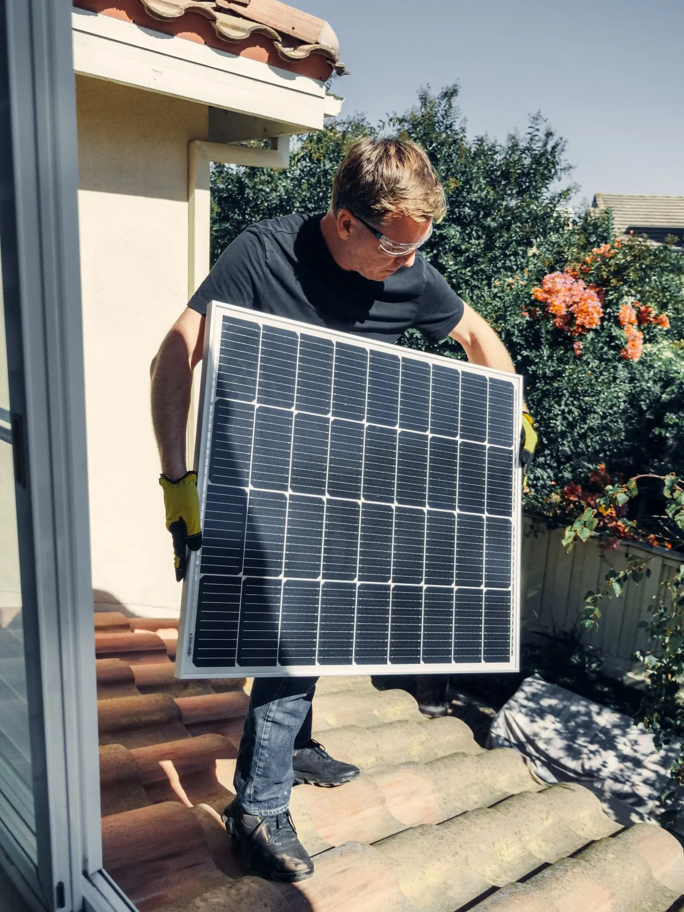 Double Glazing — Solar installer carrying a panel onto a residential roof. Photo by Kindel Media on Pexels