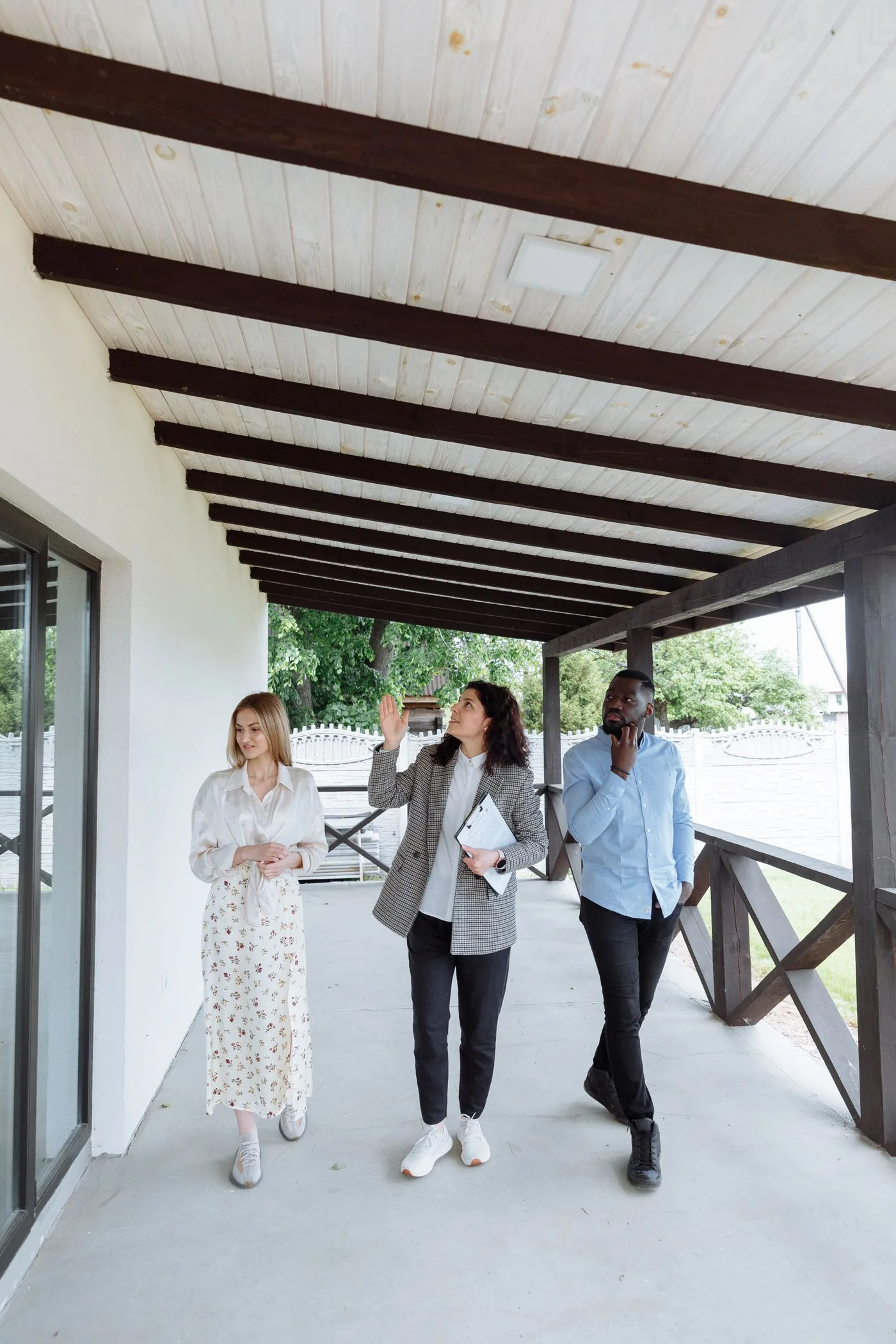 Mortgage Broking — Real estate agent with clients viewing a property on the porch. Photo by Thirdman on Pexels