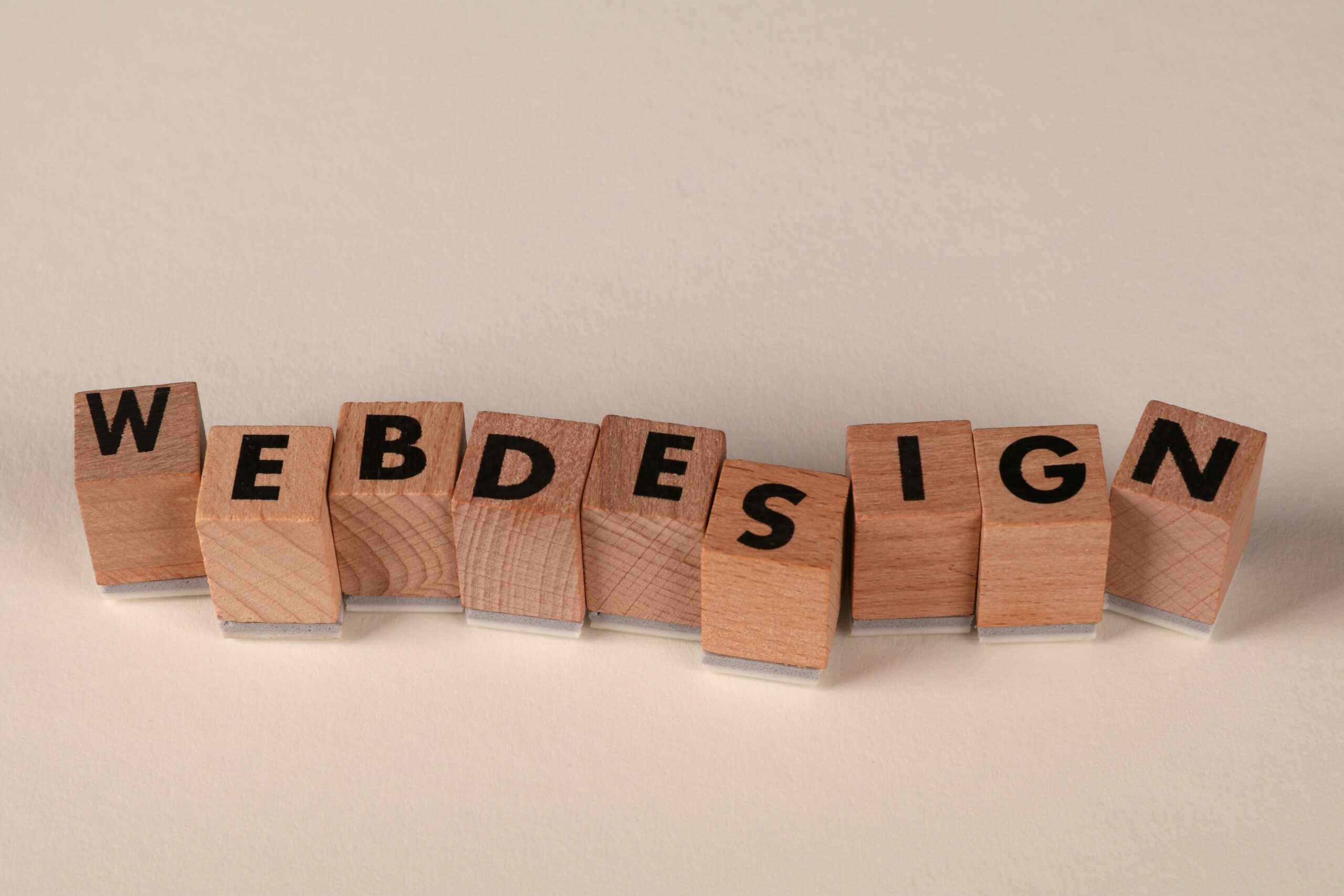 Wooden blocks spelling 'web design' creatively showcase digital design concept. Wooden blocks spelling 'web design' creatively showcase digital design concept.